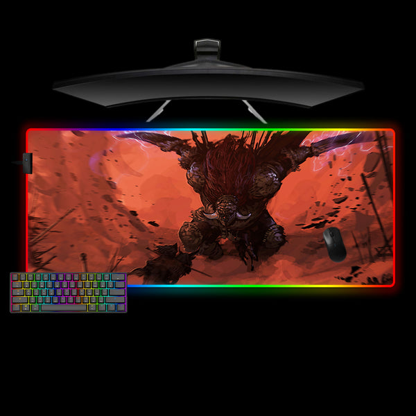 Gaming desk setup with a large RGB lit mouse pad featuring an Elden Ring Radahn design, keyboard, and monitor on a black background.