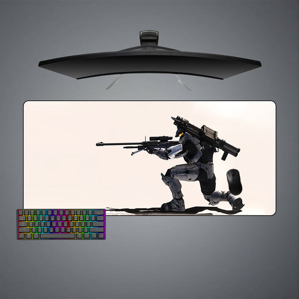 Gaming desk setup with an xl size mouse pad featuring a Halo Sniper design, keyboard, and monitor on a gray background.
